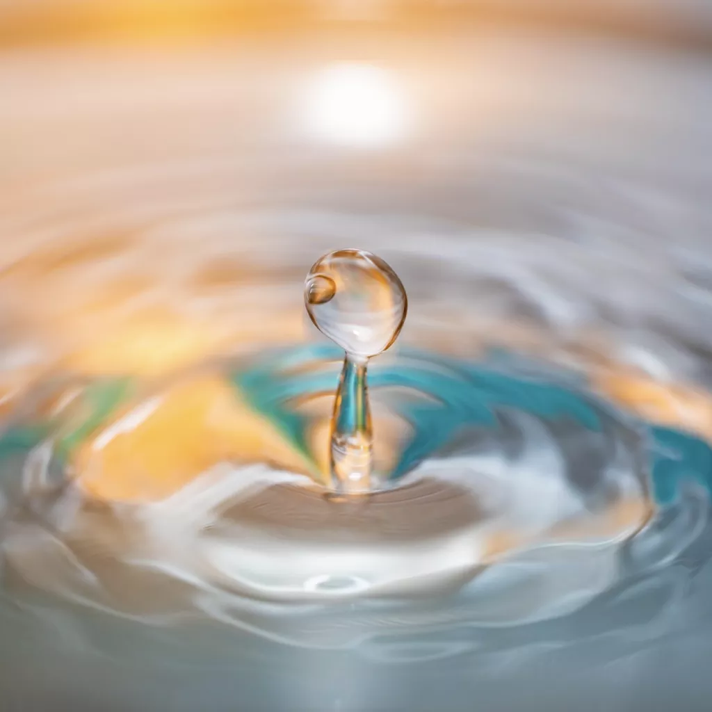 A water droplet with ripples radiating out.